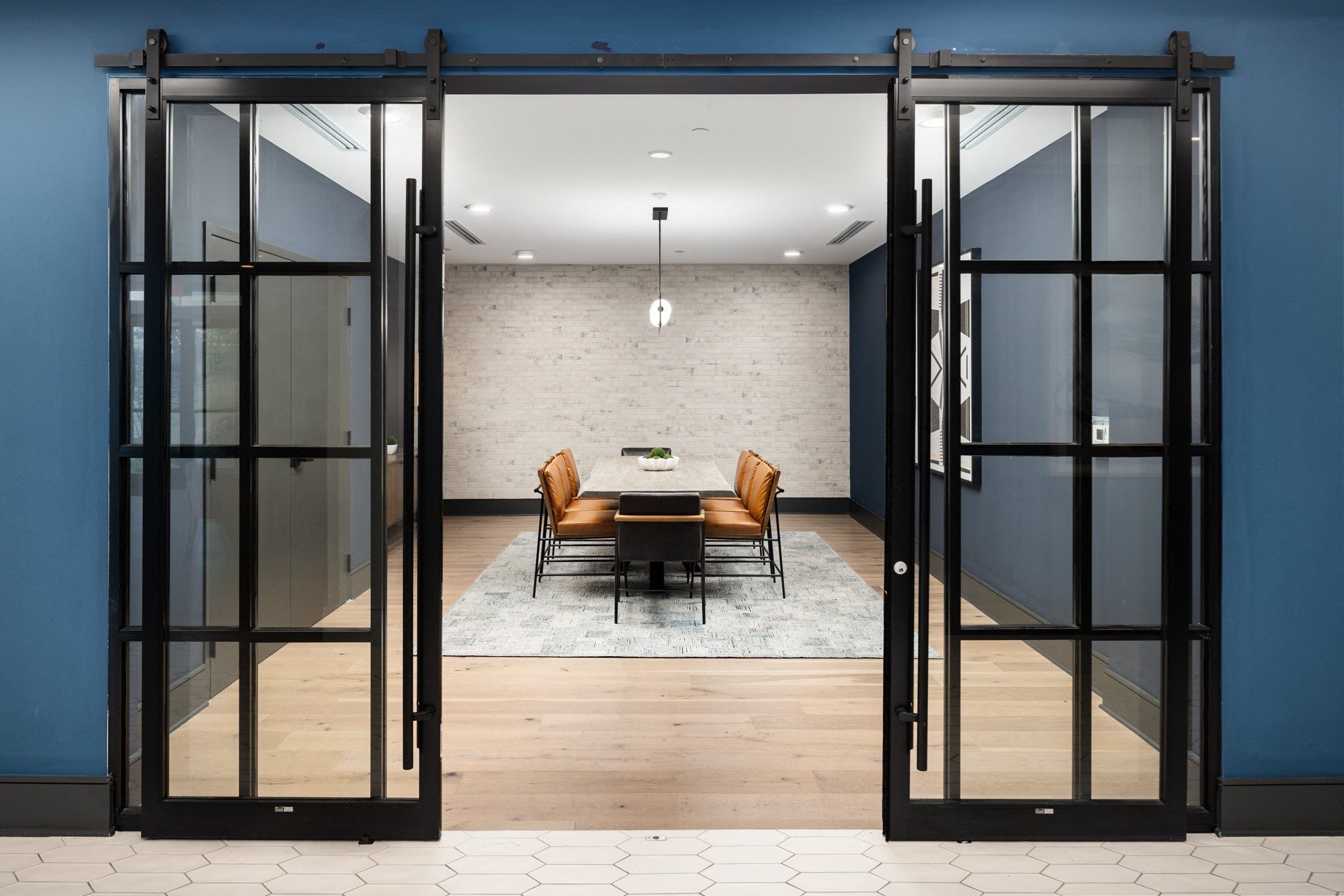 a conference room with glass doors and a table and chairs
